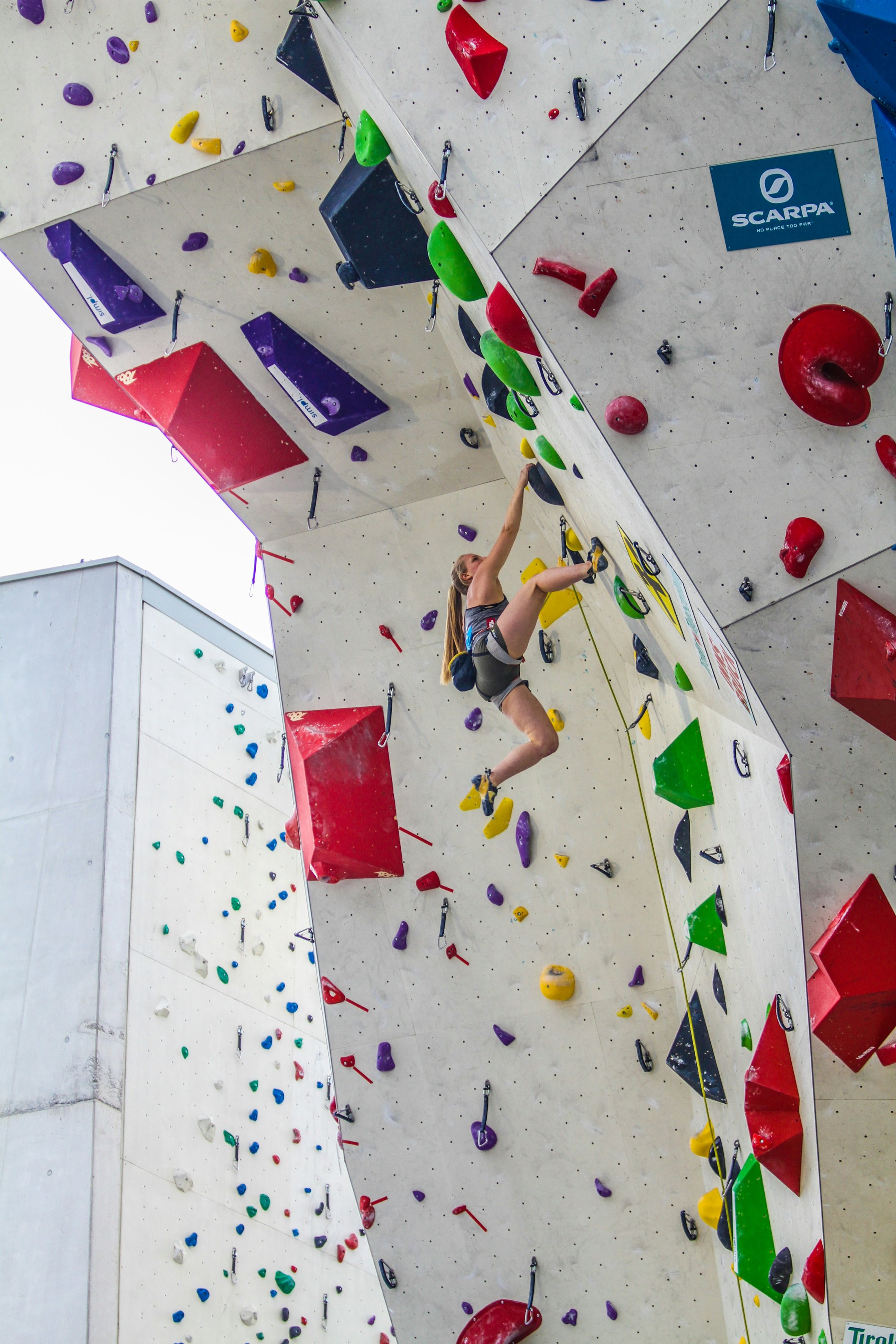 Climber reaching for a hold on an indoor climbing wall